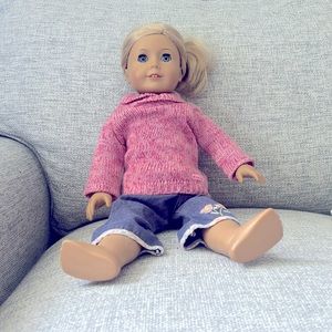 American girl doll with sweater and jeans.